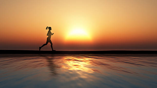 istock Female jogging against a sunset ocean 492146925