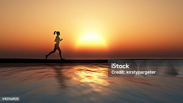 Female Jogging Against A Sunset Ocean Stock Photo - Download Image Now - Adult, Back Lit, Backgrounds