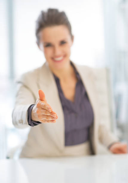 istock closeup on smiling business woman stretching hand for handshake 492147605
