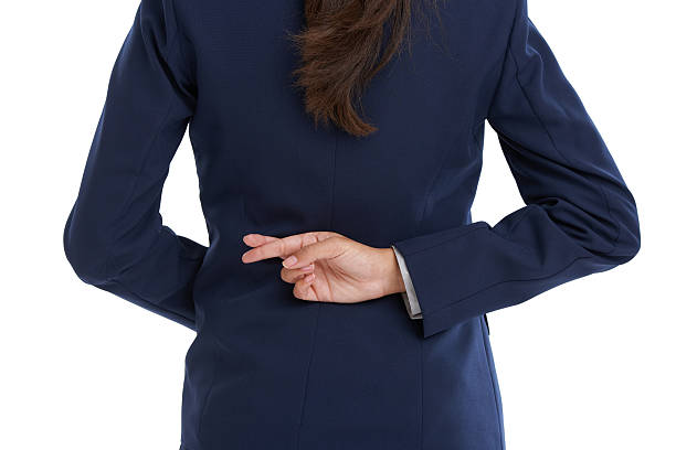 She's got questionable ethics Rear view shot of a businesswoman with her fingers crossed behind her back in studio hands behind back stock pictures, royalty-free photos & images