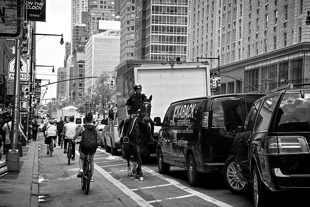 bicyclists passando nypd polícia montada, midtown manhattan, nova york city - caucasian three dimensional shape men sky imagens e fotografias de stock