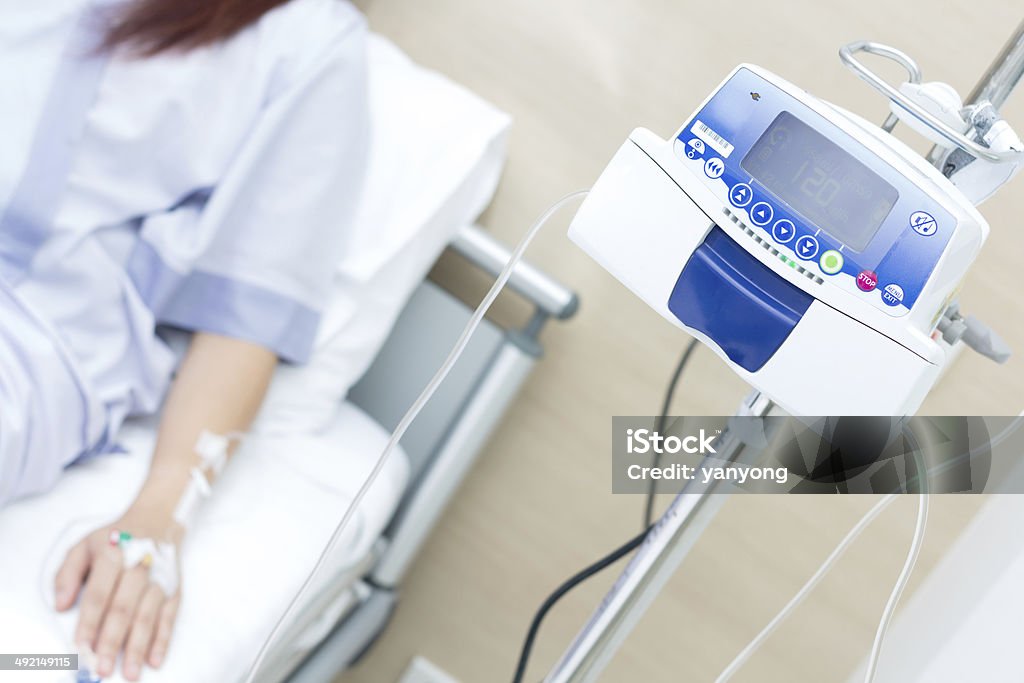 IV solution in a patient hand and IVS machine Chemotherapy Drug Stock Photo