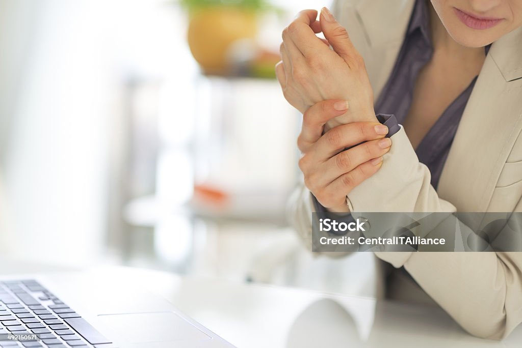 closeup on business woman with wrist pain Closeup on business woman with wrist pain Pain Stock Photo