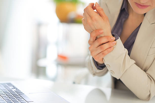 closeup on business woman with wrist pain Closeup on business woman with wrist pain tendon photos stock pictures, royalty-free photos & images