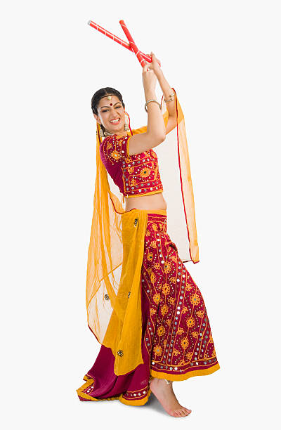 Woman in lehenga choli performing dandiya dance stock photo