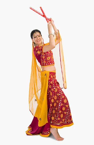 Woman in lehenga choli performing dandiya dance
