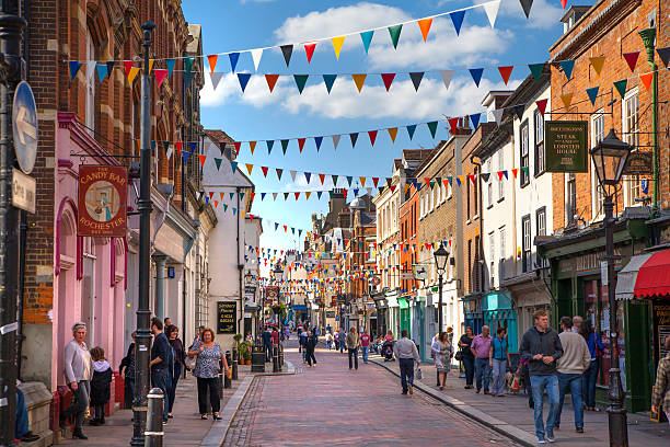 Rochester high street at weekend with lots of people Rochester, UK - May 16, 2015: Rochester high street at weekend. People walking through the street, passing cafes, restaurants and shops kent england photos stock pictures, royalty-free photos & images
