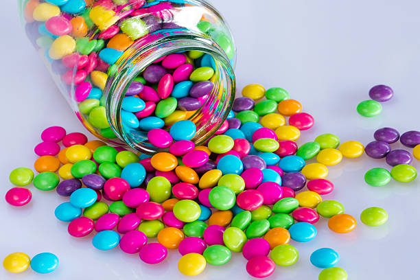 istock Colorful candies with glass jar on white background 492156310