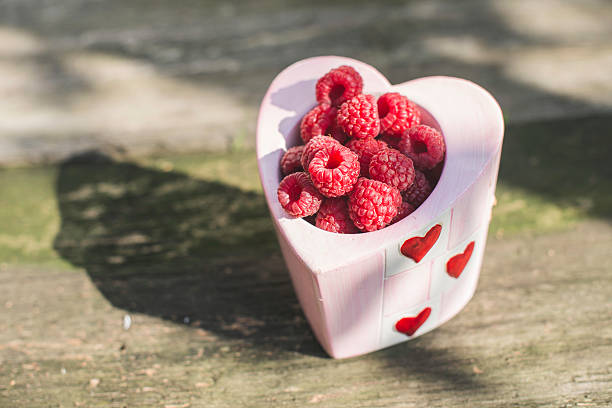 istock Raspberries in a bowl on wood 492157476