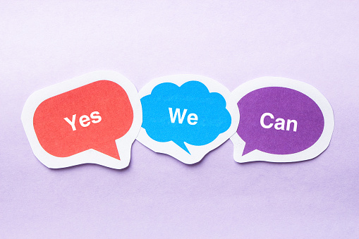 Yes we can concept paper bubbles against purple background.