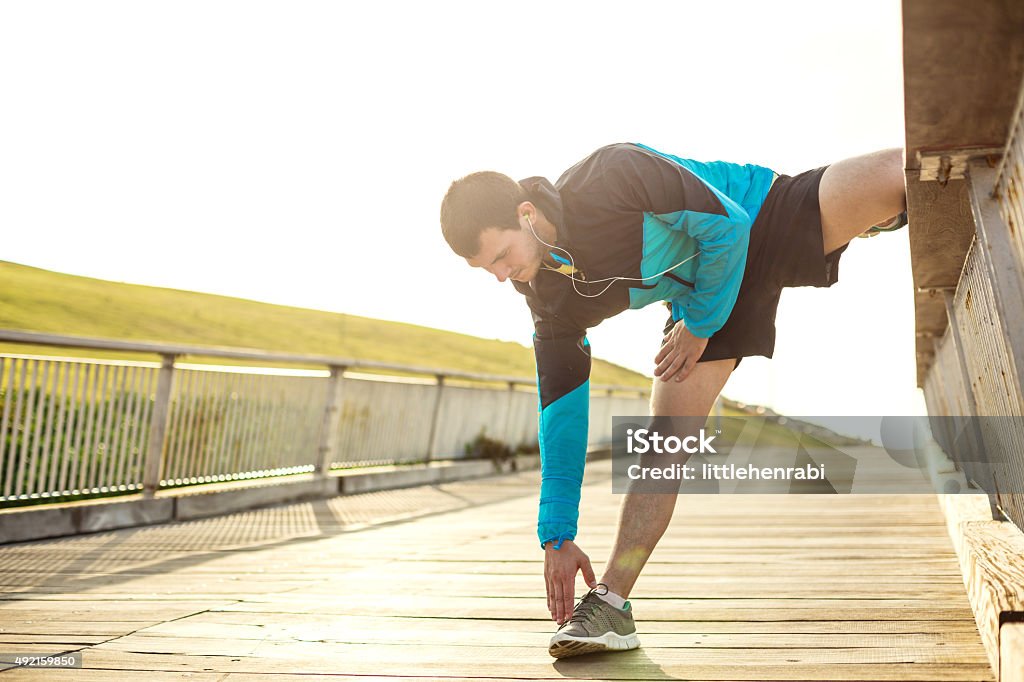 sportsman doing warming stretching athletic sportsman doing warming stretching exercise in the park 2015 Stock Photo