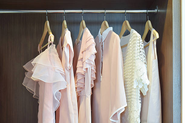 istock Sweet pastel blouses are hanging in open wooden wardrobe 492186556
