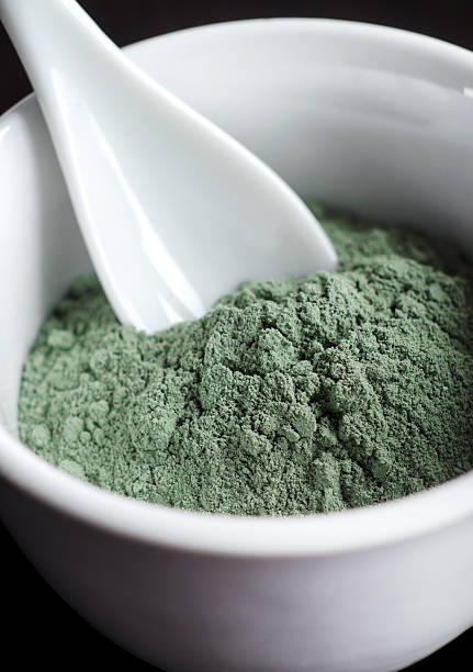 Green cosmetic clay powder in a bowl Green cosmetic clay powder in a bowl green clay stock pictures, royalty-free photos & images