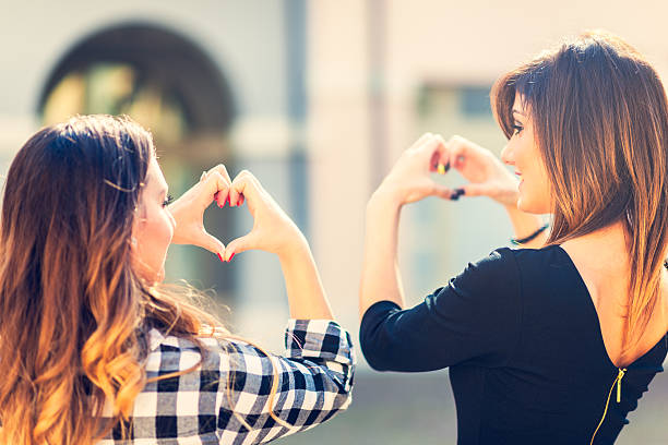 istock Two young woman making a heart shape by hands 492194144