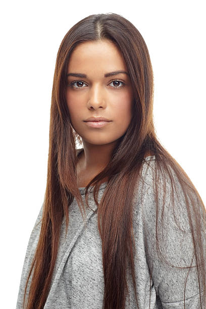 Studio portrait of a attractive young woman posing against a white background in denim jeans and a black tank top