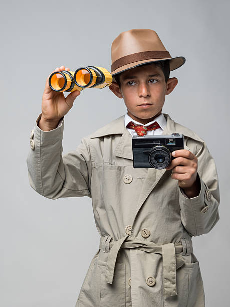 little детектив, глядя через binogulars на серый фон - little boys discovery binoculars child стоковые фото и изображения
