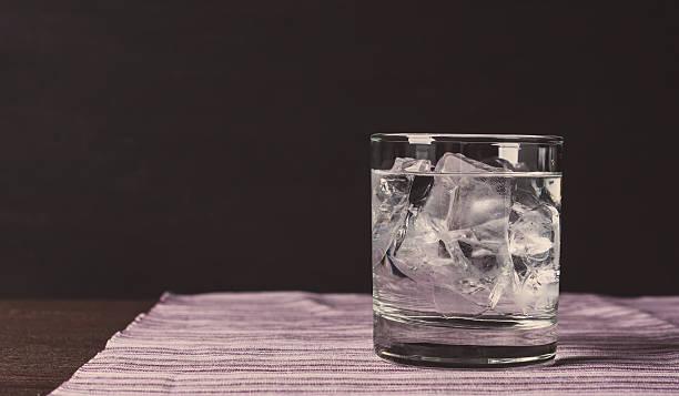 Glass of vodka on the rocks Glass of vodka on the rocks. Vintage style. Toned image. club soda stock pictures, royalty-free photos & images