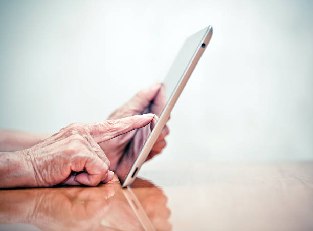Old man using digital tablet stock photo