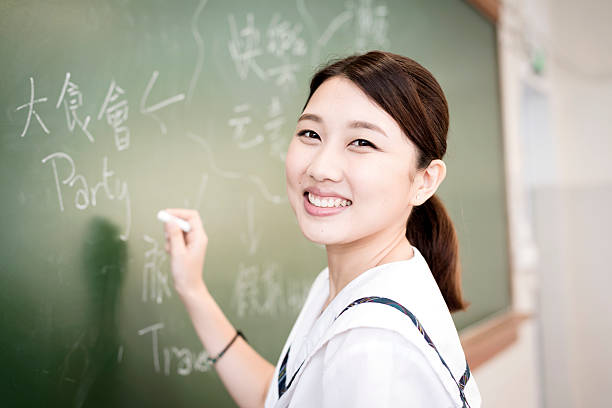 Female Student Writing Happy Words, Chinese and English, Hong Kong stock photo