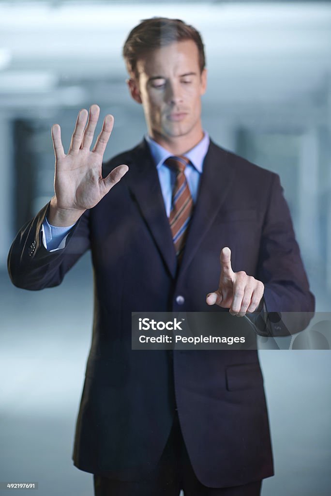 Focused on his work Cropped shot of a handsome young businessman using a digital interface 20-29 Years Stock Photo