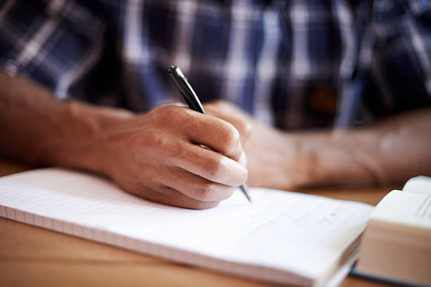 Let the work flow Closeup shot of a young student writing on a note pad exam paper stock pictures, royalty-free photos & images