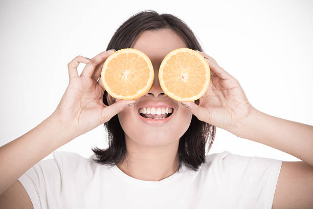 istock Young woman holding fresh oranges. Healthy eating. Isolated over 492198608