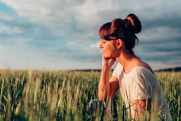 istock Girl sits in a meadow 492199756