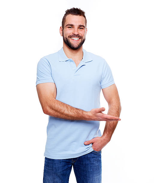 feliz jovem em camisa pólo mostrando em branco copyspace - blue polo shirt - fotografias e filmes do acervo