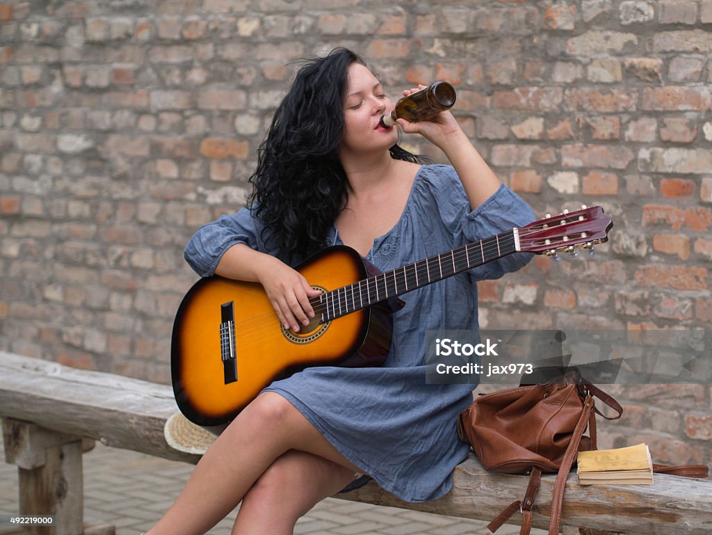 festival feelings young and sexy woman with guitar drinking a beer 2015 Stock Photo