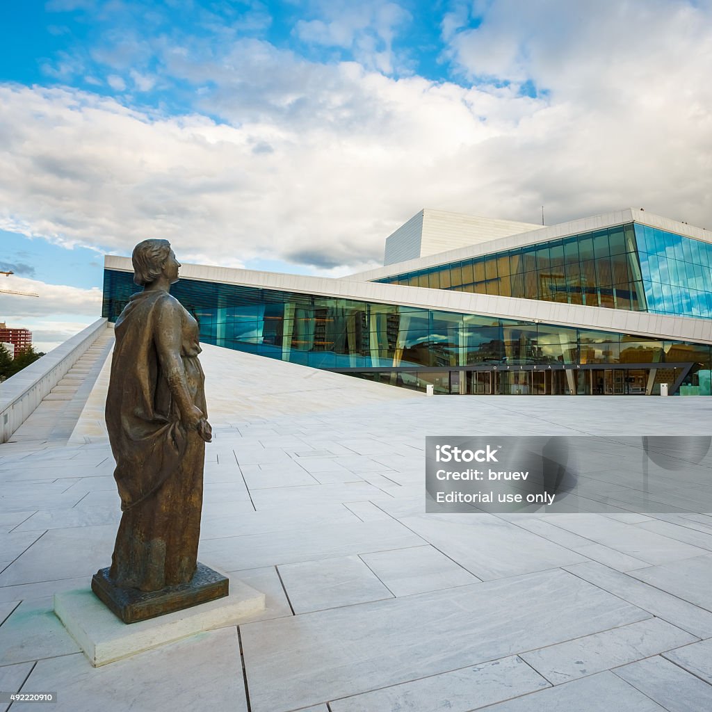 The Oslo Opera House is home of Norwegian National Opera Oslo, Norway - July 31, 2014: The Oslo Opera House Is The Home Of The Norwegian National Opera And Ballet. The Roof Of Building Angles To Ground Level Creating A Plaza Inviting Pedestrians To Walk Up And Enjoy Views Of Oslo. 2015 Stock Photo