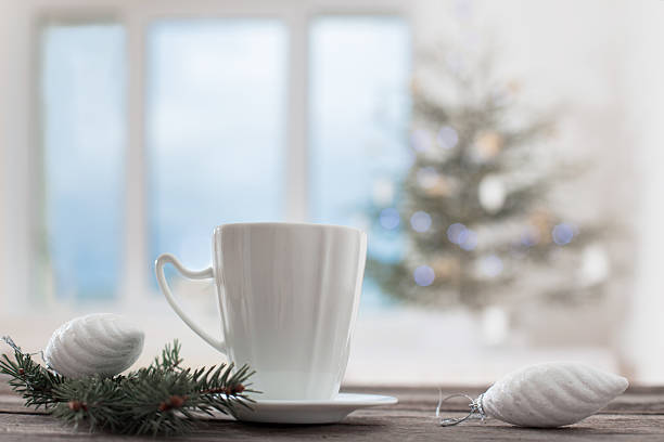 white cup on background Christmas fir and window