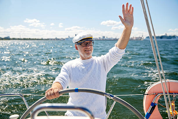 senior hombre en puesto de mando en barco de vela en el mar - helm nautical vessel sailing ship sailing fotografías e imágenes de stock