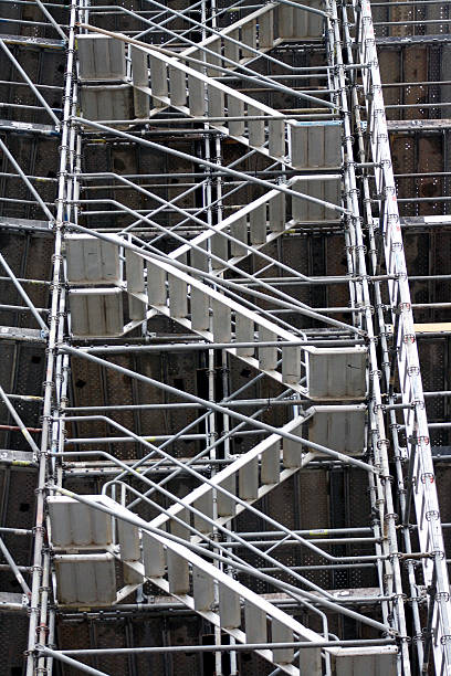 Renovation work with scaffolding on snowy facade side view in winter isolated on white
