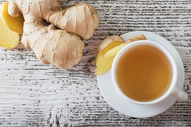 tè allo zenzero in una tazza bianca su sfondo in legno - drink brown herb heat foto e immagini stock