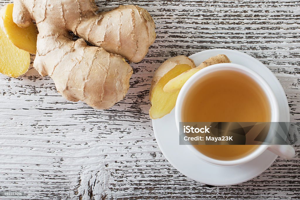 Ginger tea in a white cup on wooden background Ginger - Spice Stock Photo