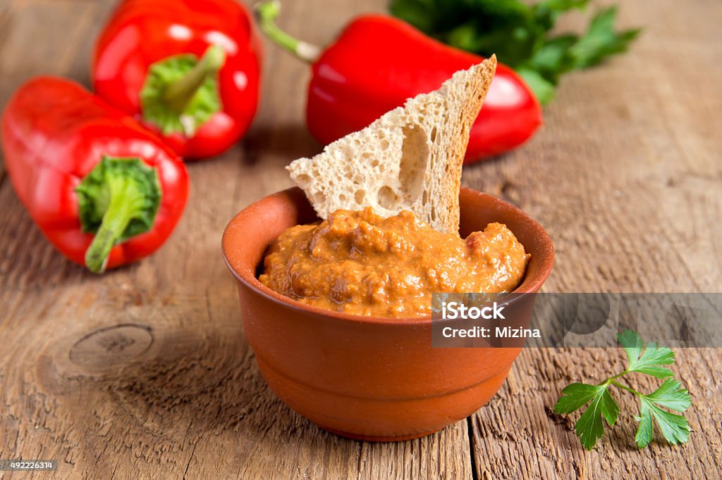 roasted pepper dip roasted pepper dip with nuts and bread in ceramic bowl over rustic wooden background closeup 2015 Stock Photo