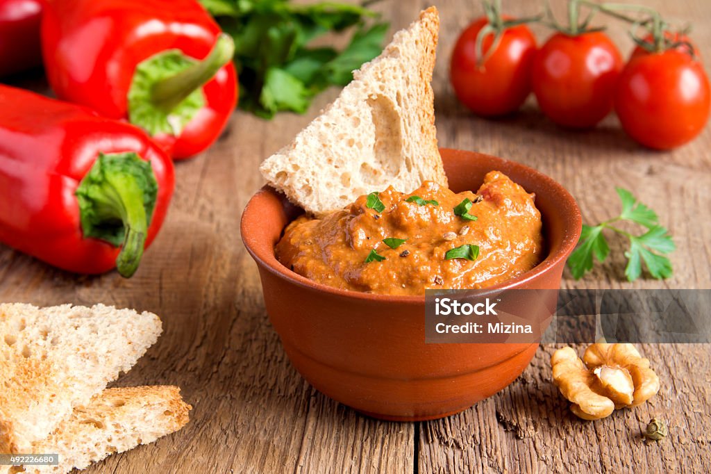 roasted pepper dip roasted pepper dip with nuts and bread in ceramic bowl over rustic wooden background closeup Pepper - Vegetable Stock Photo