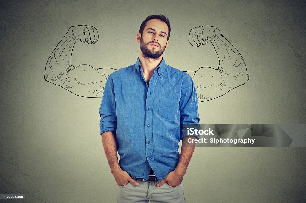 Strong man, self confident young entrepreneur Strong man, self confident young entrepreneur standing isolated on gray wall background. Arrogant bold self-important uppity snobbish stuck up man Arrogance Stock Photo