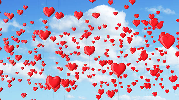istock red heart shaped balloons in the blue sky with clouds. 492228282