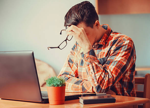 istock Tired young man sitting over the laptop 492229926