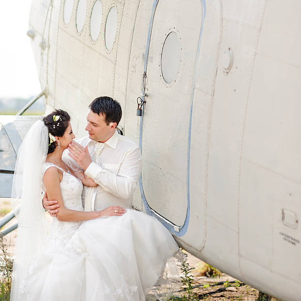 istock Wedding summer couple together posing against airplane. 492232698