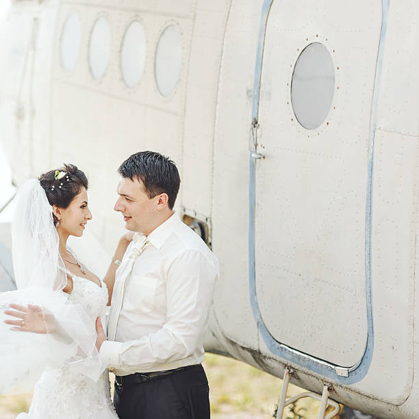 istock Wedding summer couple together posing against airplane. 492233050