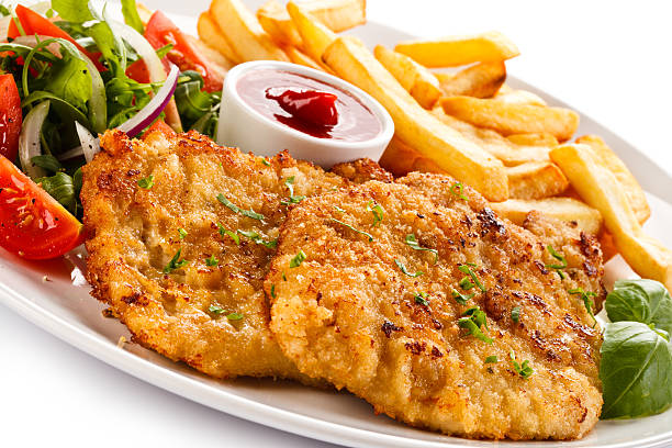 istock Fried steaks, French fries and vegetables 492251708