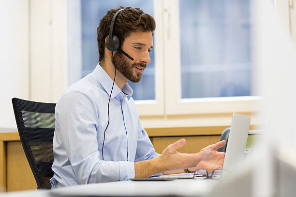 Happy Businessman in the office on the phone, headset, Skype stock photo