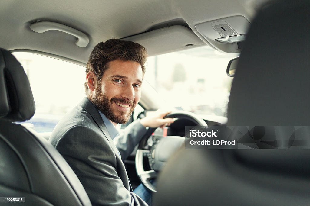 Portrait of man in his car. looking camera Handsome man in his car driving and facing camera Car Stock Photo