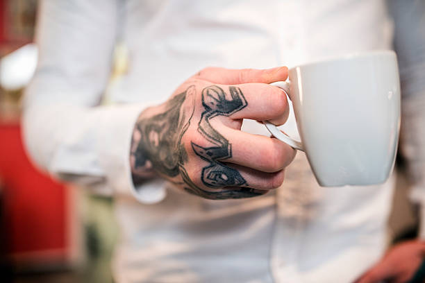 istock Tattoo artist holding coffee cup 492255428