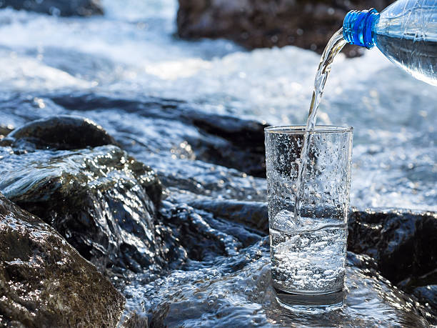 istock Water pouring into a glass from bottle 492258316
