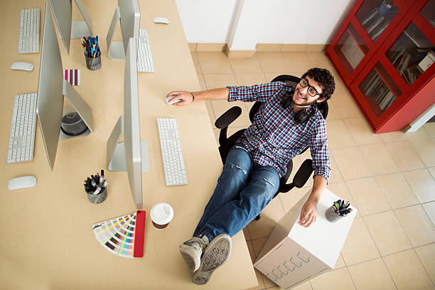 jeune homme travaillant avec les pieds sur son bureau - color swatch audio photos et images de collection