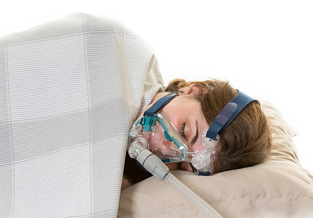 Medical treatment for sleep apnea in a woman Hispanic woman sleeping and wearing the CPAP mask for the sleep apnea treatment woman stealth stock pictures, royalty-free photos & images