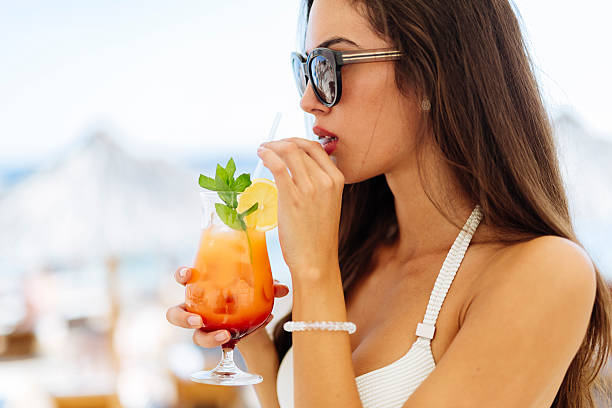 istock Attractive woman drinking cocktail side portrait 492261224